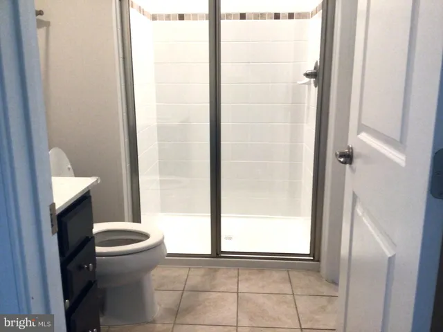 a bathroom with a granite countertop toilet and a shower