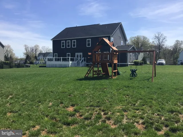a view of a house with a big yard and a fountain