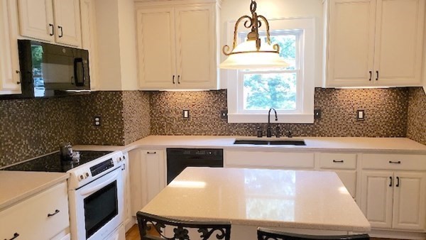 45 Wachusett Street Springfield, MA 01118 - Photo 5 of 23 a kitchen with stainless steel appliances a stove a sink cabinets and a window