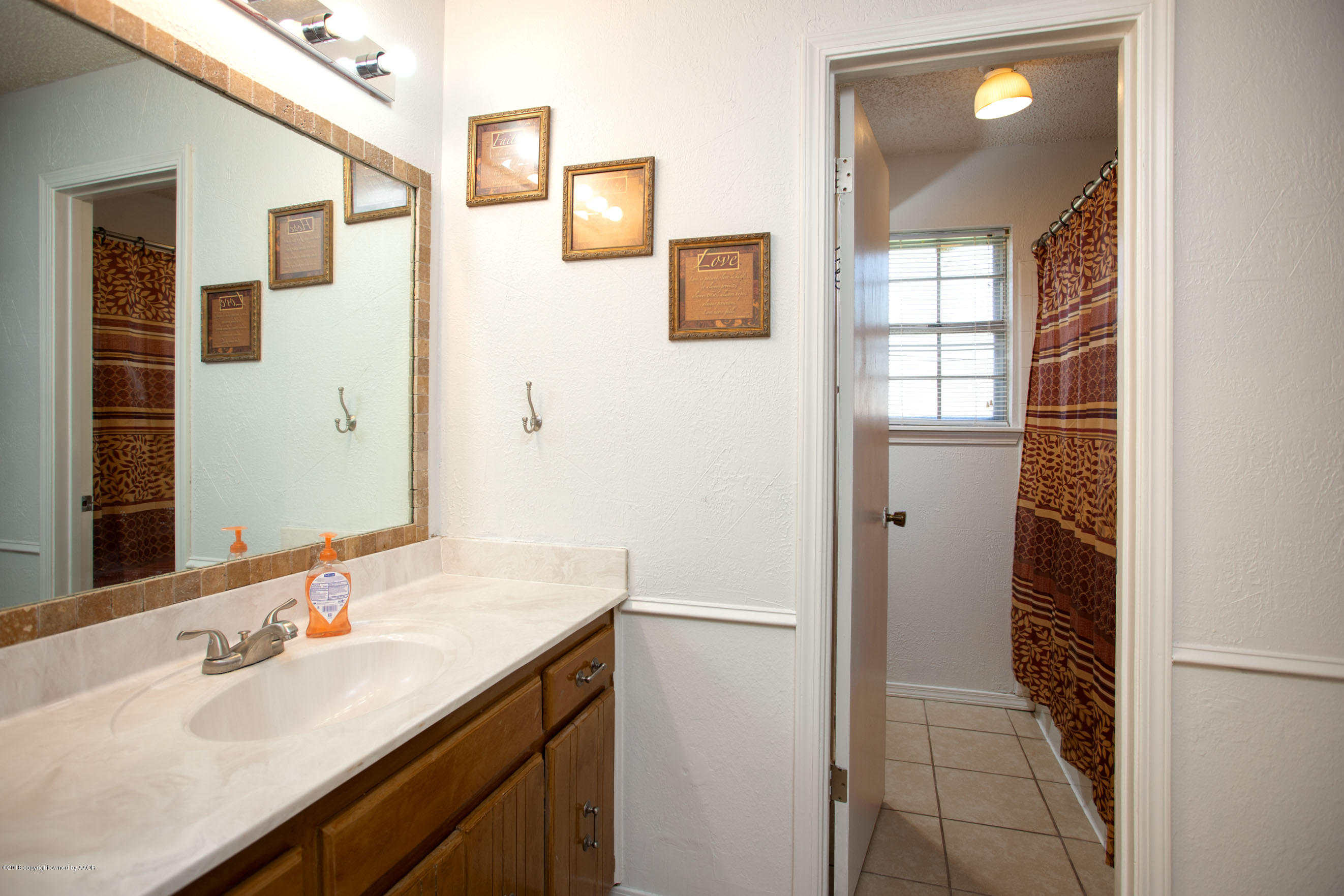 5328 Capulin Lane Amarillo, TX 79110 - Photo 13 of 17 a bathroom with a sink a vanity and a mirror