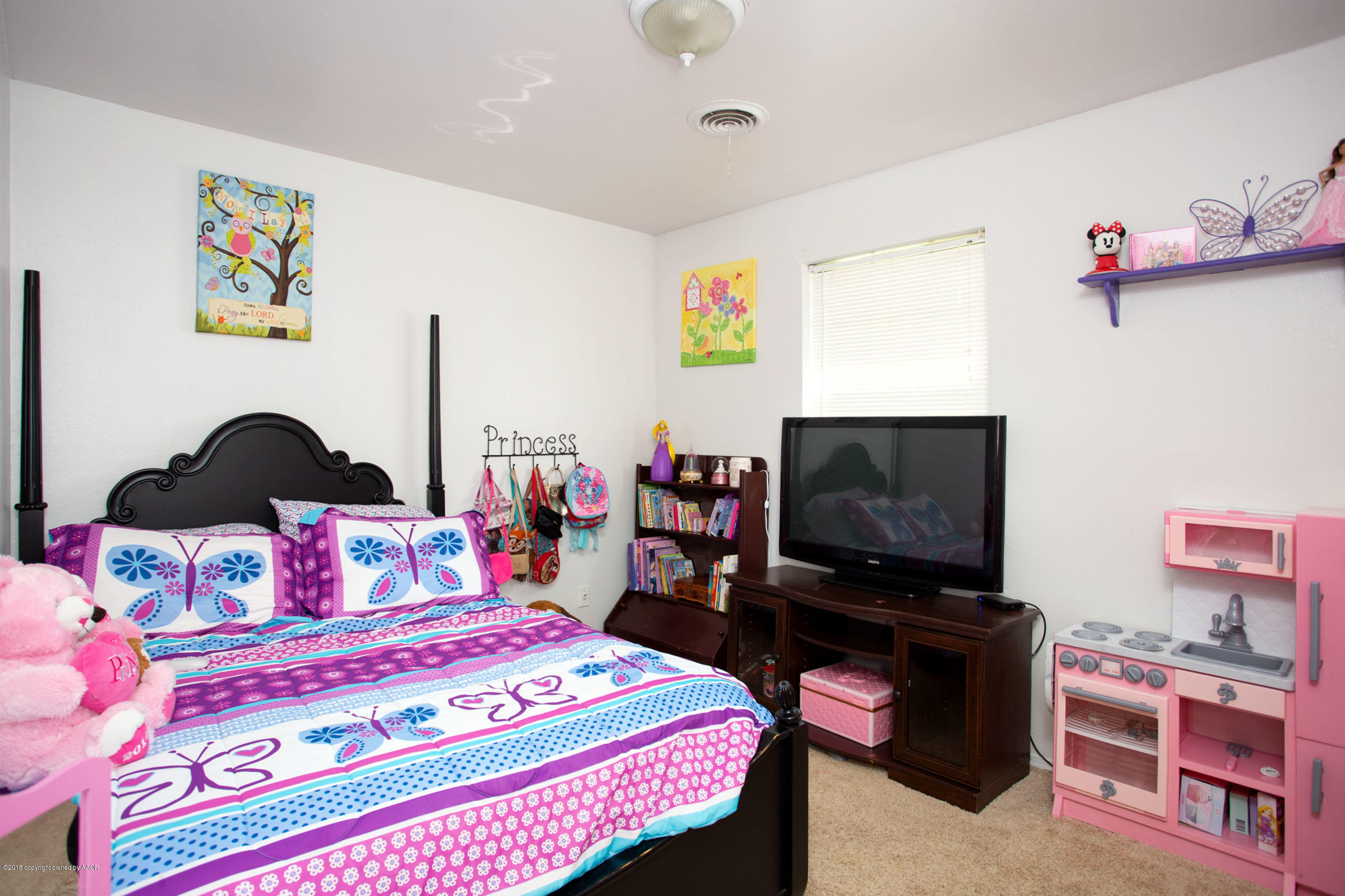 5328 Capulin Lane Amarillo, TX 79110 - Photo 14 of 17 a bedroom with a bed and a flat screen tv