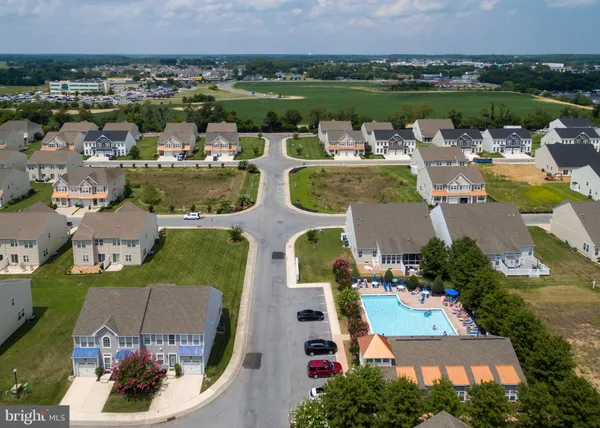 a kitchen with stainless steel appliances granite countertop a refrigerator a sink a stove and white cabinets with wooden floor