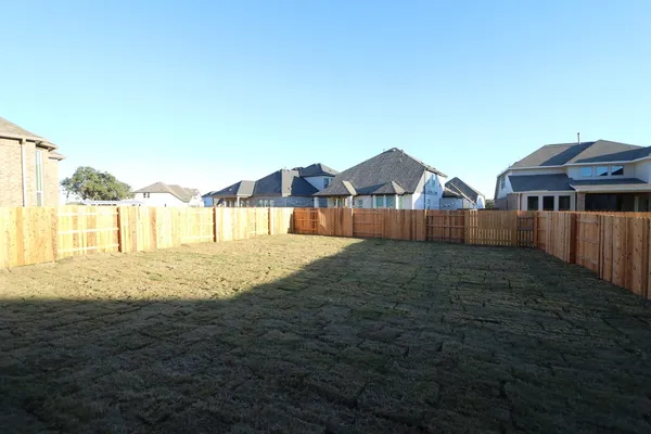 a view of an house with backyard and tree