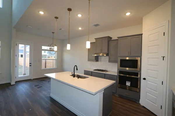 a kitchen with a sink a counter space appliances and cabinets