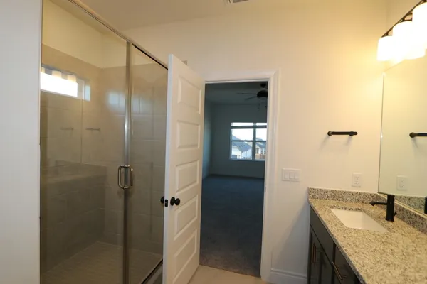 a bathroom with a granite countertop shower mirror and a sink
