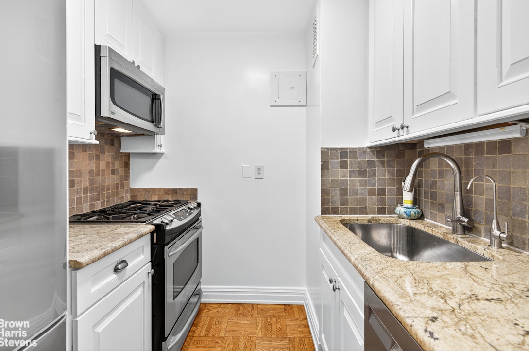 520 East 72nd Street, Unit 3F Manhattan, NY 10021 - Photo 5 of 15 a kitchen with granite countertop a sink stove and cabinets
