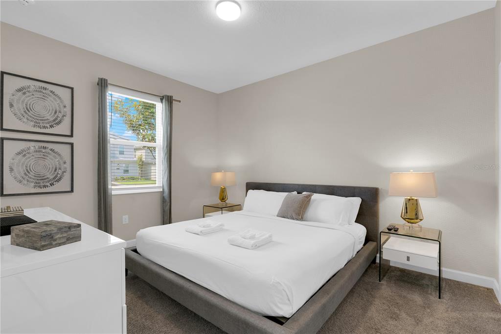 4530 Narrative Lane Kissimmee, FL 34746 - Photo 11 of 98 a bedroom with a bed and a night stand