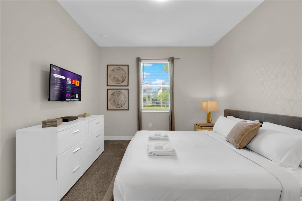 4530 Narrative Lane Kissimmee, FL 34746 - Photo 12 of 98 a bedroom with a bed and a flat screen tv on the dresser