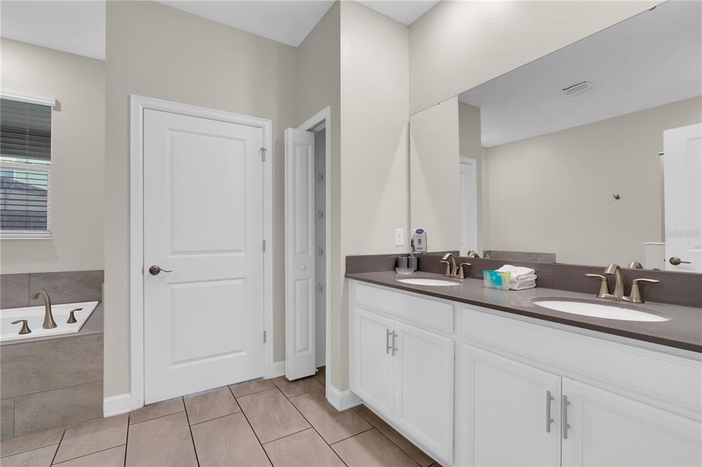 4530 Narrative Lane Kissimmee, FL 34746 - Photo 32 of 98 a bathroom with a double vanity sink and mirror