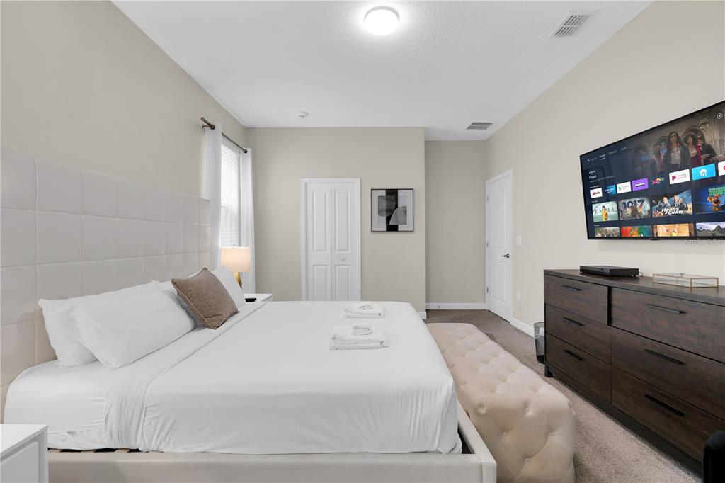4530 Narrative Lane Kissimmee, FL 34746 - Photo 34 of 98 a bedroom with a large bed and a flat screen tv
