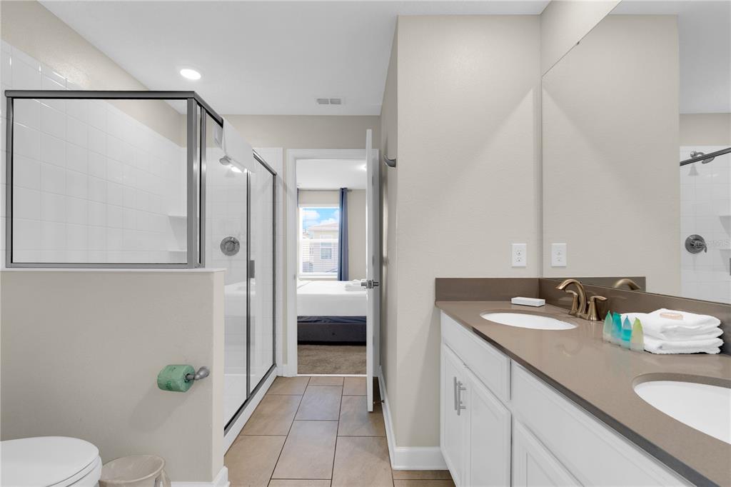 4530 Narrative Lane Kissimmee, FL 34746 - Photo 58 of 98 a bathroom with a granite countertop sink toilet and shower