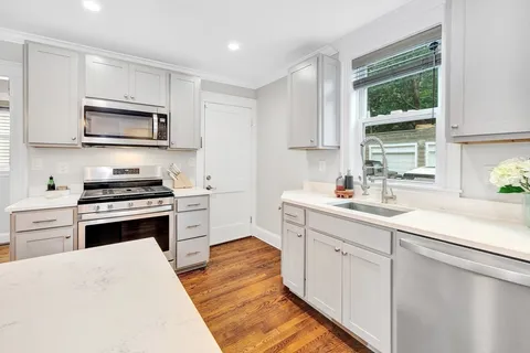 a kitchen with cabinets stainless steel appliances and a window