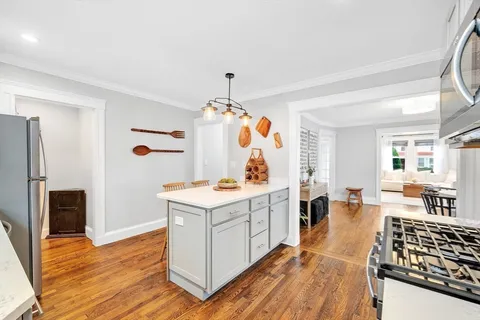 a view of kitchen island with wooden floor and electronic appliances