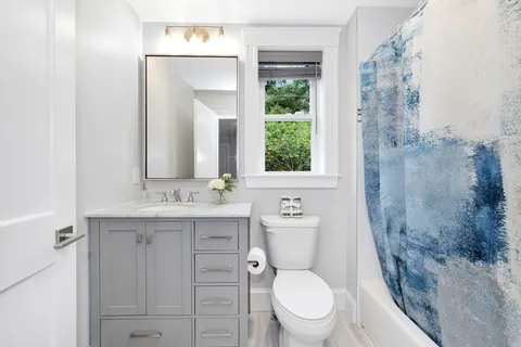 a bathroom with a granite countertop toilet sink and mirror