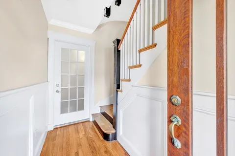 a view of an entryway with wooden floor and door