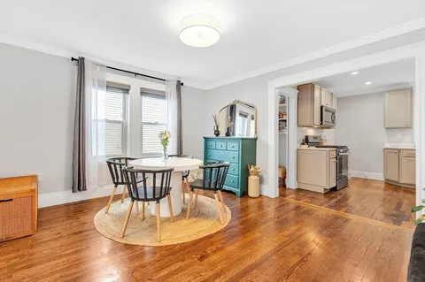 a dining room with furniture and wooden floor