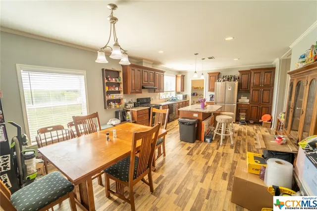 a kitchen with stainless steel appliances a stove a sink dishwasher and a refrigerator with wooden floor