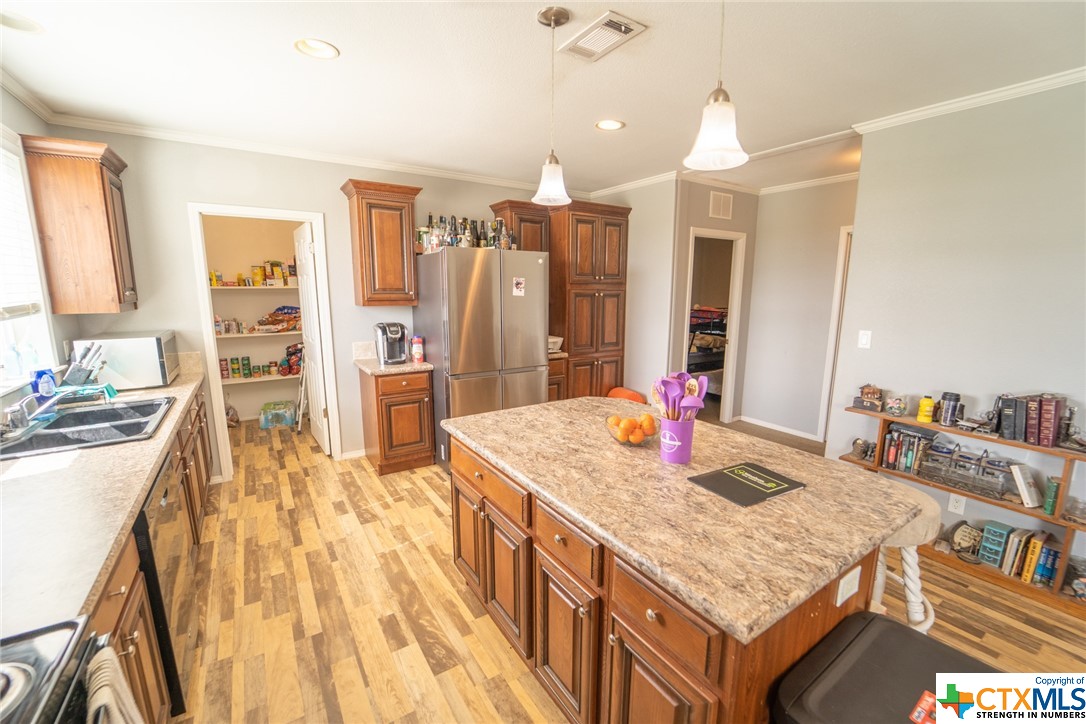 443 Joe Pokluda Road Nordheim, TX 78141 - Photo 20 of 26 a open kitchen with granite countertop a sink dishwasher stove and refrigerator