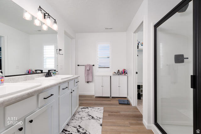 540 Lefty Lane Tooele, UT 84074 - Photo 26 of 48 Bathroom with double vanity, a stall shower, and light wood-type flooring