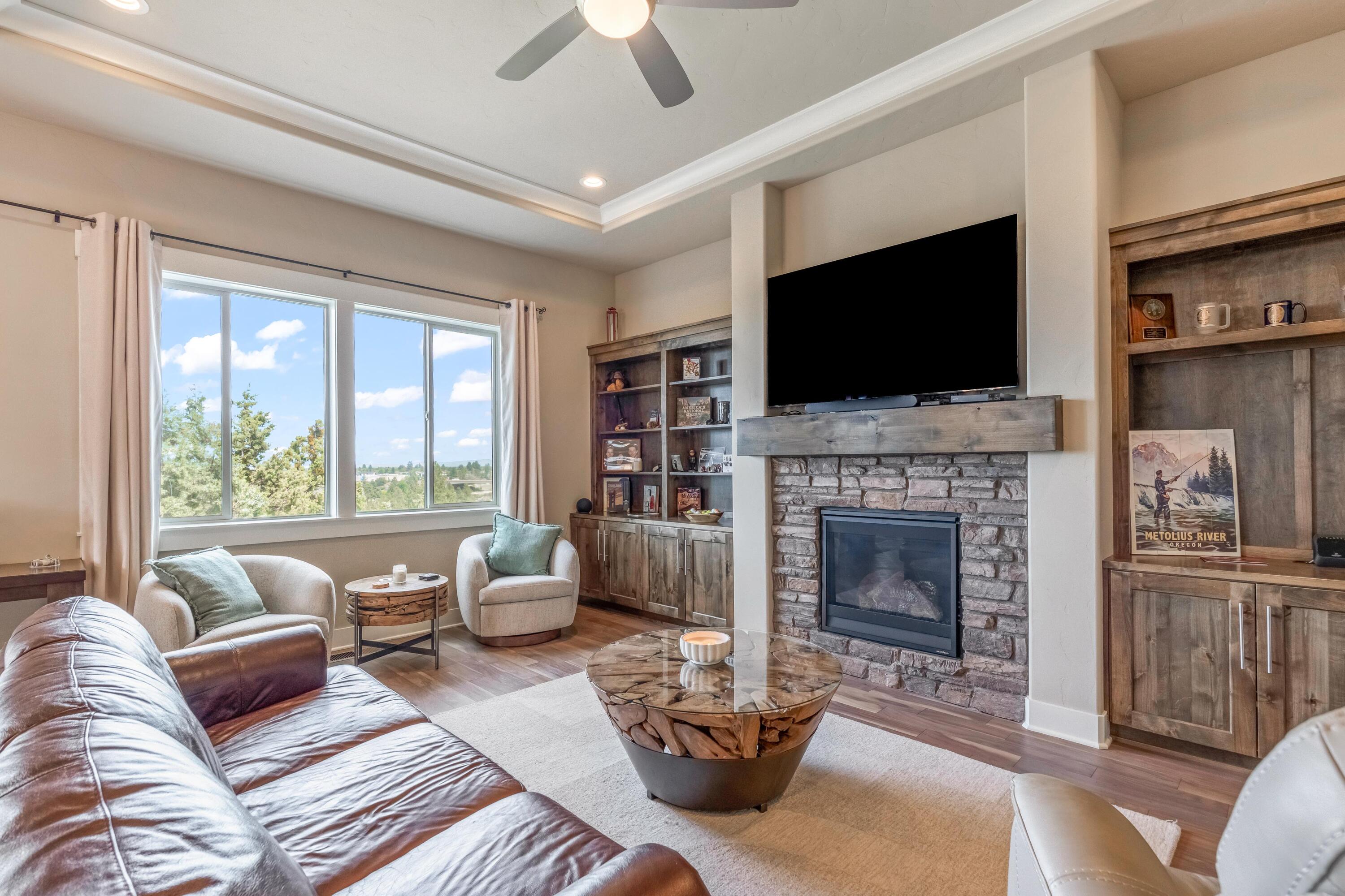 2375 Northwest Majestic Ridge Drive Bend, OR 97703 - Photo 5 of 28 a living room with furniture a flat screen tv and a fireplace