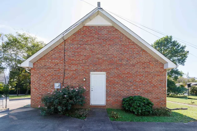 a brick house with a yard and plants