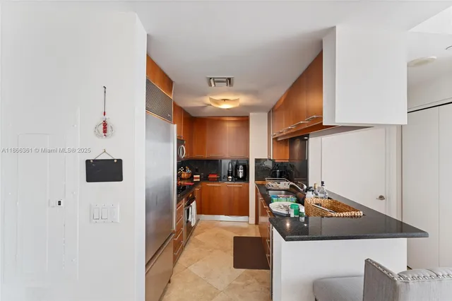 a kitchen that has a lot of cabinets a sink and appliances in it