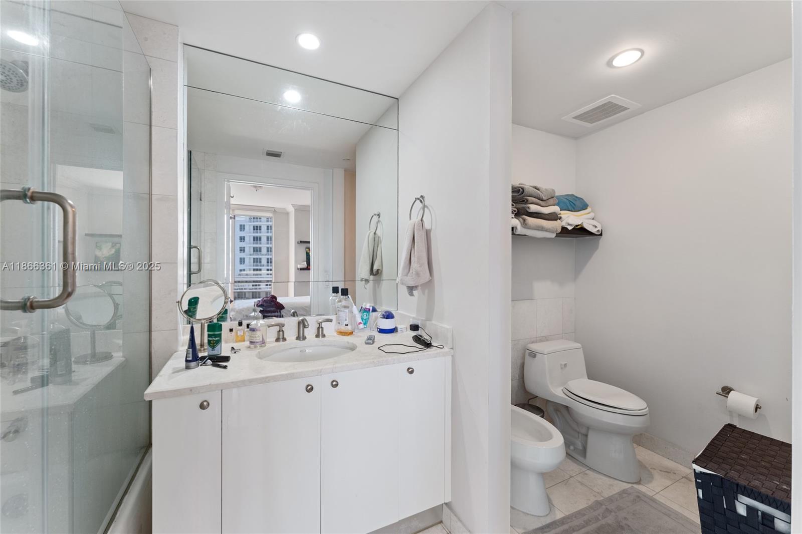 901 Brickell Key Boulevard, Unit 2801 Miami, FL 33131 - Photo 21 of 22 a bathroom with a sink toilet vanity and shower
