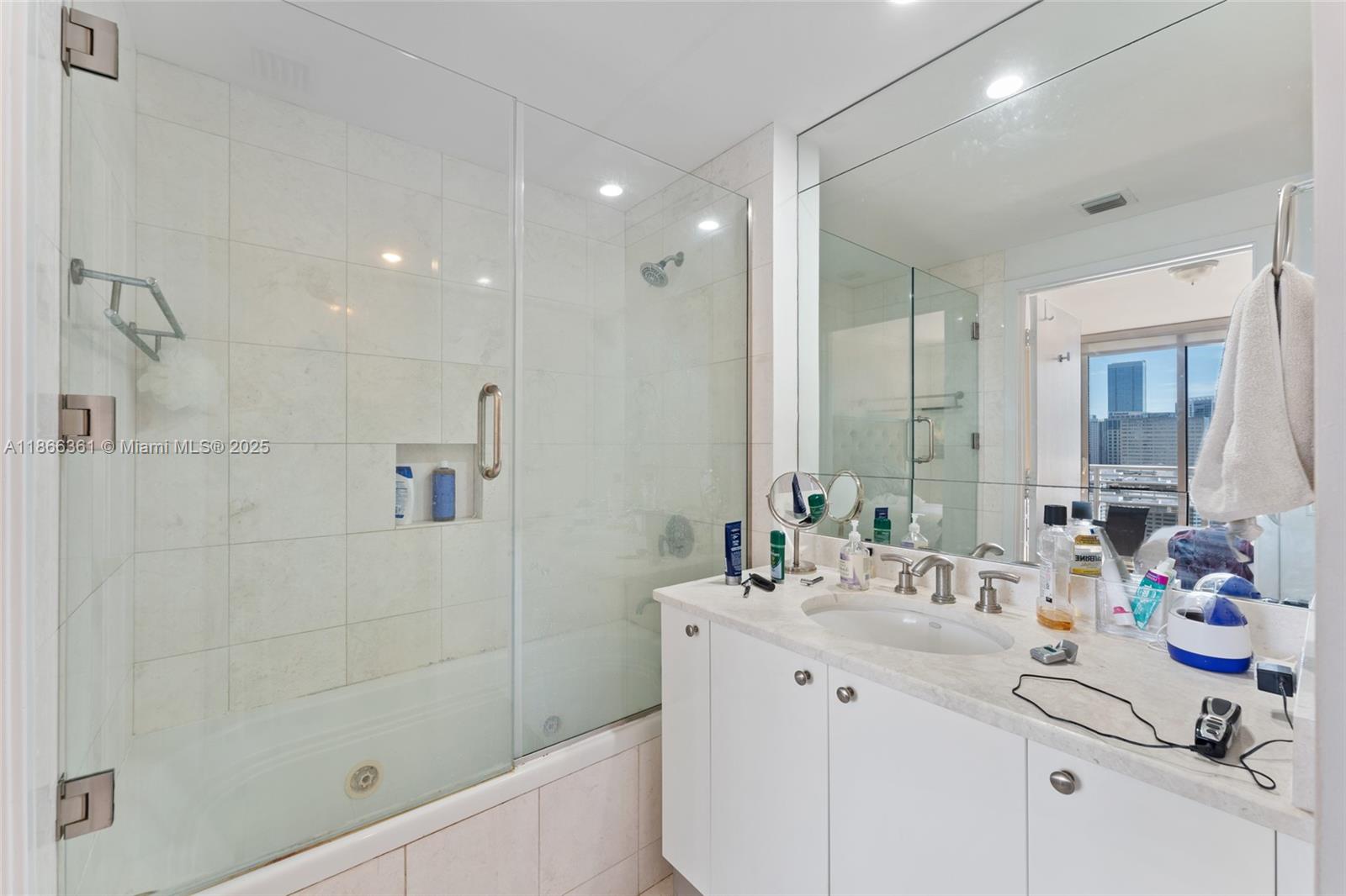 901 Brickell Key Boulevard, Unit 2801 Miami, FL 33131 - Photo 22 of 22 a bathroom with a double vanity sink mirror and shower