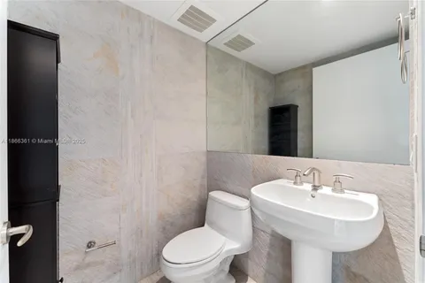 a bathroom with a sink toilet and a mirror