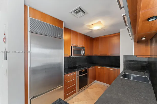a kitchen with stainless steel appliances granite countertop a refrigerator and a sink