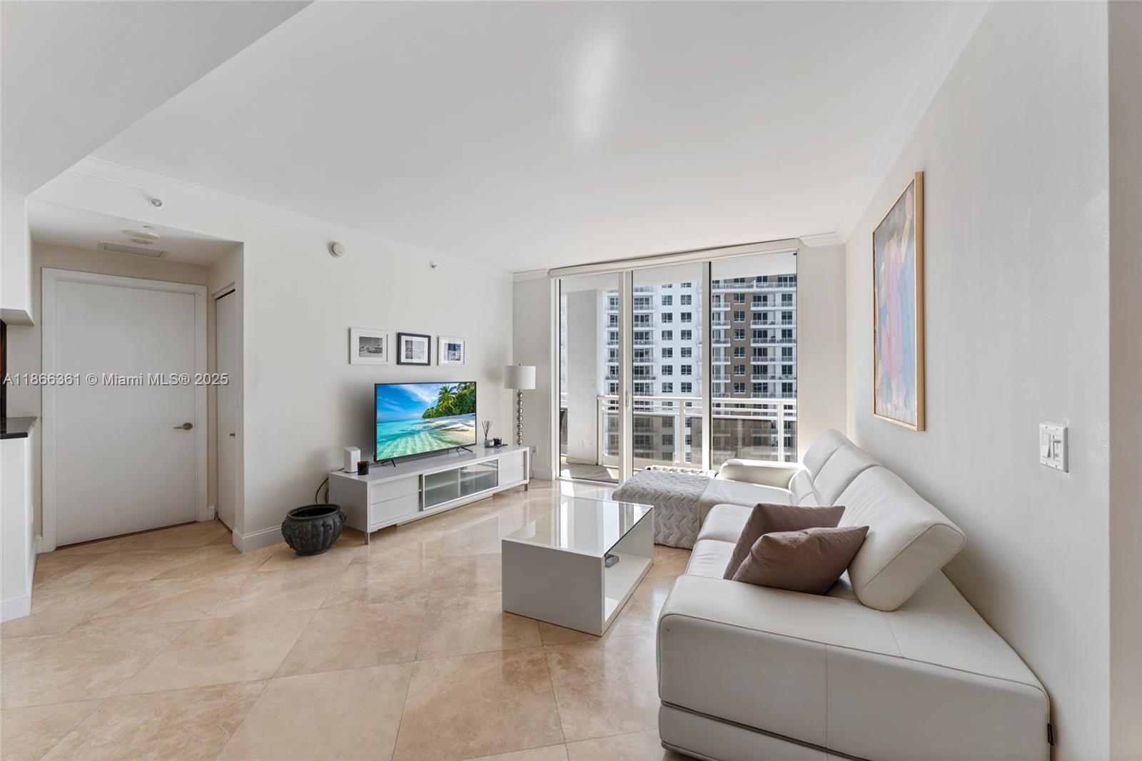 901 Brickell Key Boulevard, Unit 2801 Miami, FL 33131 - Photo 6 of 22 a living room with furniture and a window
