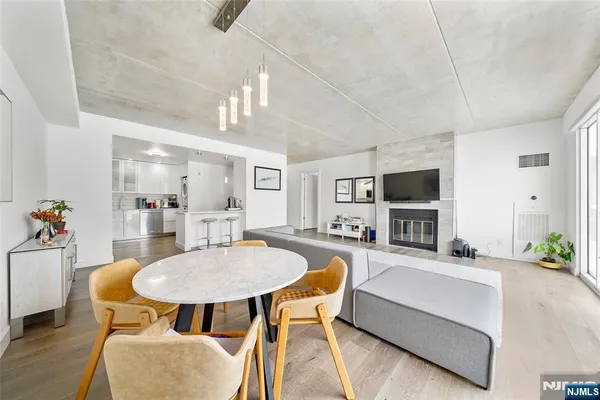 a living room with furniture a flat screen tv and kitchen view