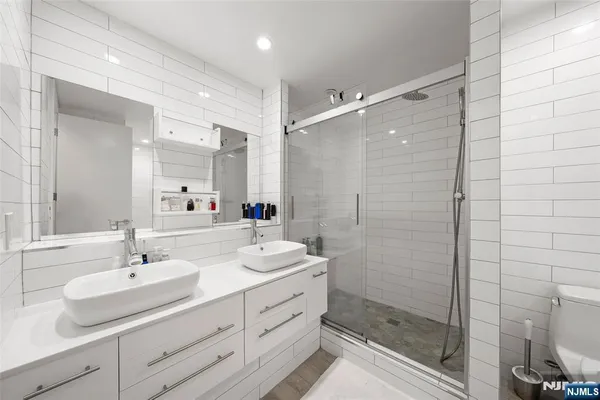 a bathroom with a double vanity sink mirror and shower