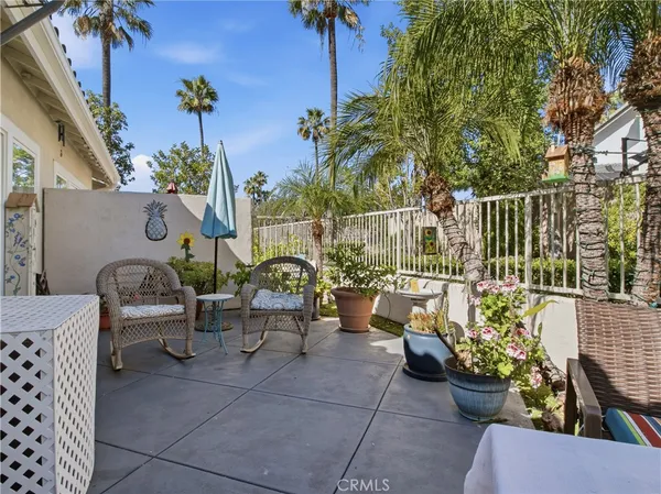a view of a patio with couches table and chairs and potted plants