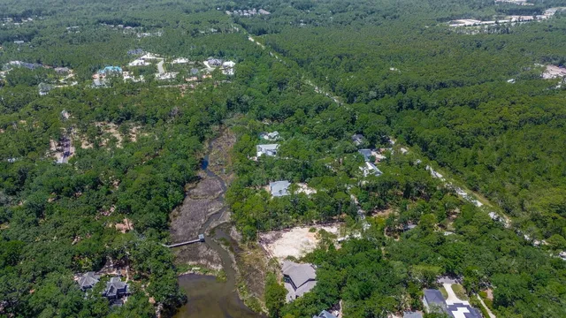 an aerial view of residential house with outdoor space and trees all around