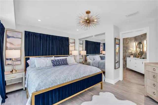 a living room with a bed furniture and kitchen view with wooden floor