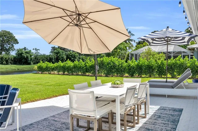 a view of a patio with a table and chairs under an umbrella