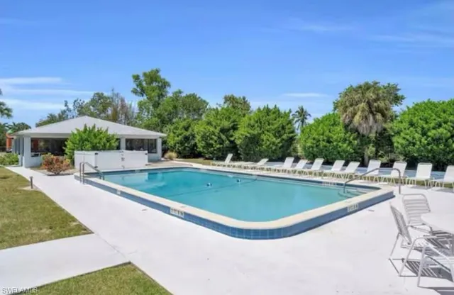 a view of a house with swimming pool and sitting area