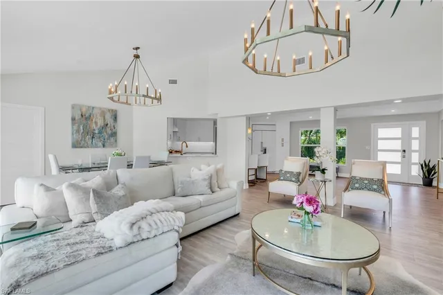 a living room with furniture a chandelier and a wooden floor