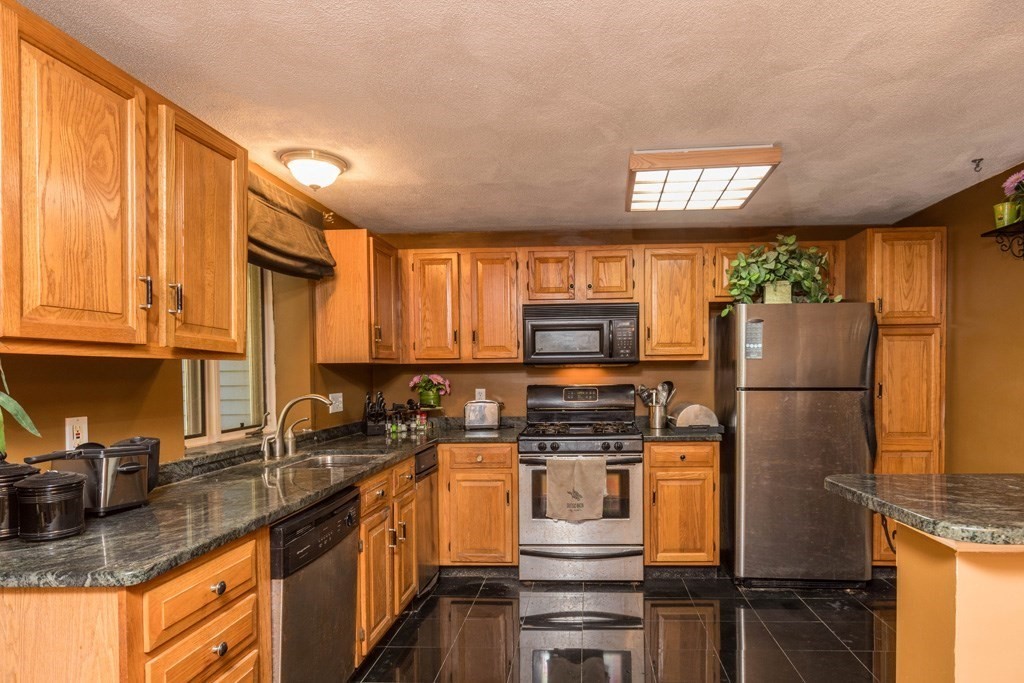 14 Deer Path, Unit 6 Maynard, MA 01754 - Photo 2 of 20 a kitchen with stainless steel appliances granite countertop a refrigerator stove microwave sink and cabinets