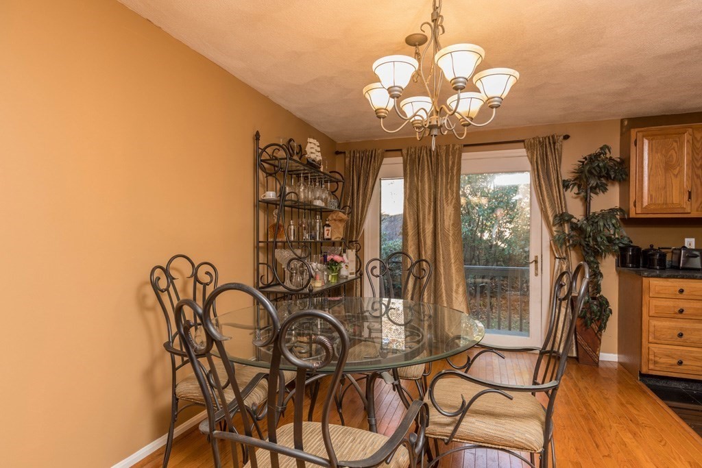 14 Deer Path, Unit 6 Maynard, MA 01754 - Photo 3 of 20 a dining room with chandelier fan and wooden floor