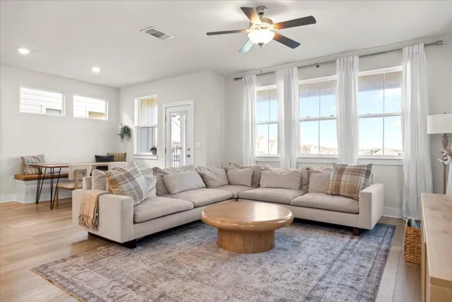 a living room with furniture a chandelier and a window