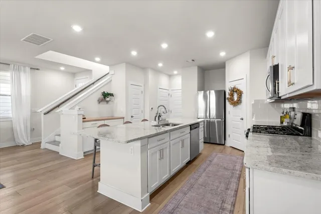 a kitchen with stainless steel appliances granite countertop a sink stove and refrigerator