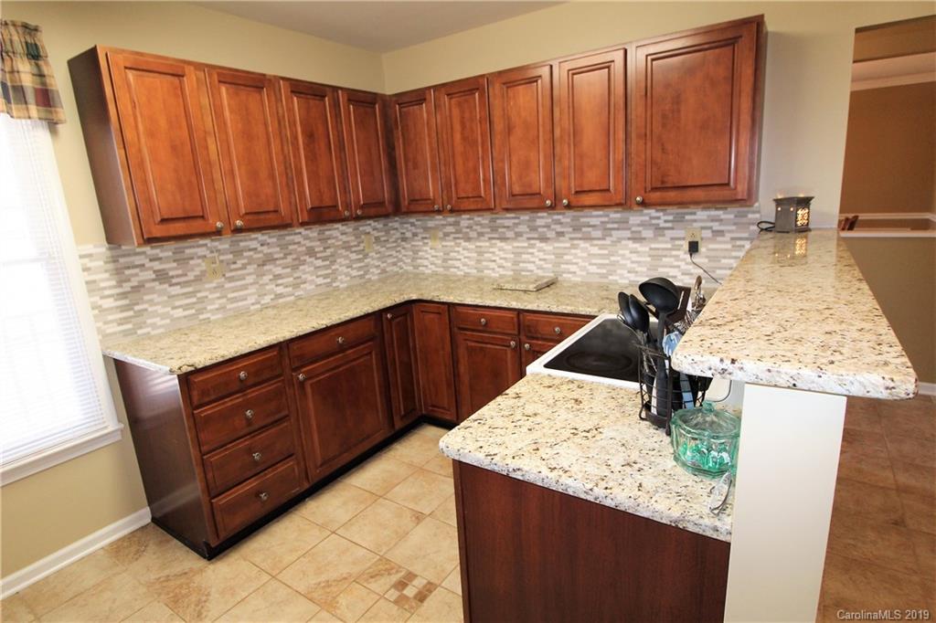 934 Beamguard Road Clover, SC 29710 - Photo 8 of 35 a kitchen with granite countertop a sink a stove and cabinets