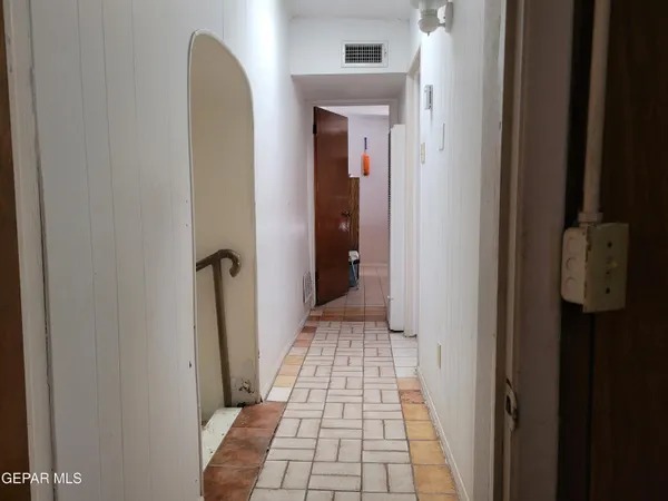a glass vase with flowers on a table in front of a window
