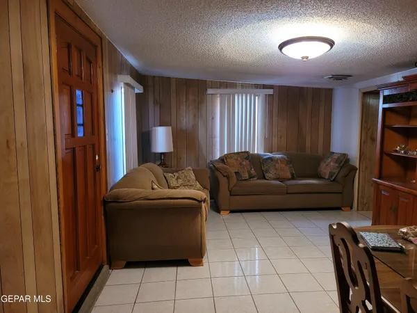 a kitchen with stainless steel appliances granite countertop a stove top oven a sink a dining table and chairs with wooden floor