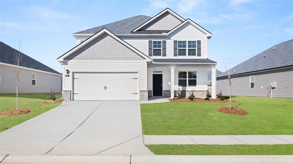 a front view of a house with a yard and garage