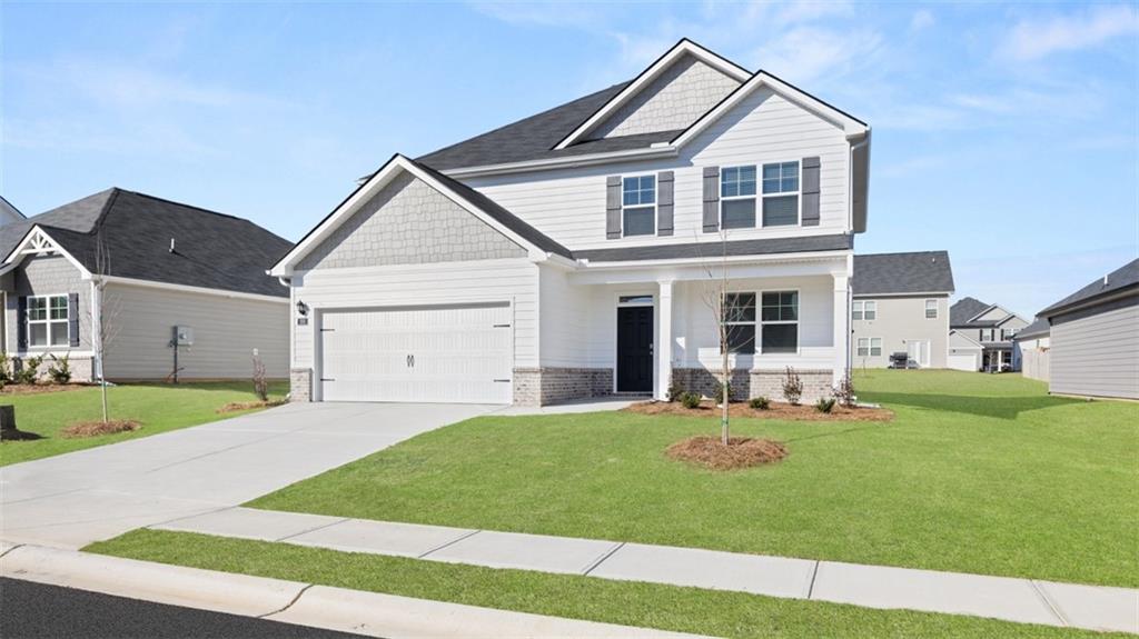 214 Cattle Drive Perry, GA 31069 - Photo 2 of 39 a front view of a house with a yard and garage