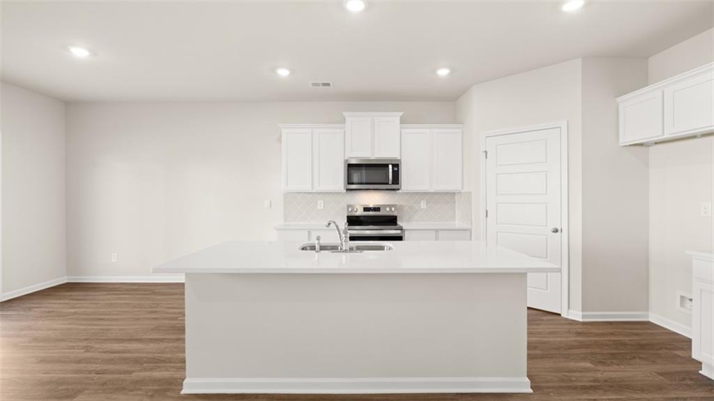 214 Cattle Drive Perry, GA 31069 - Photo 7 of 39 a kitchen with stainless steel appliances a refrigerator sink and white cabinets
