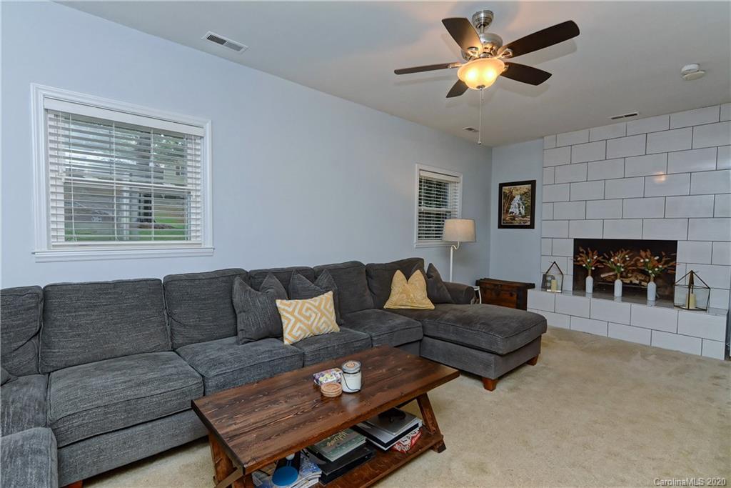 7407 Watercrest Road Charlotte, NC 28210 - Photo 23 of 42 a living room with furniture a fireplace and a flat screen tv
